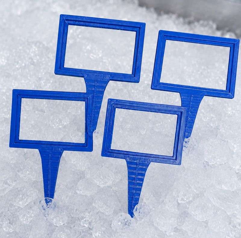Blue 3D printed sign holders staked into crushed ice in a refrigerated seafood display case