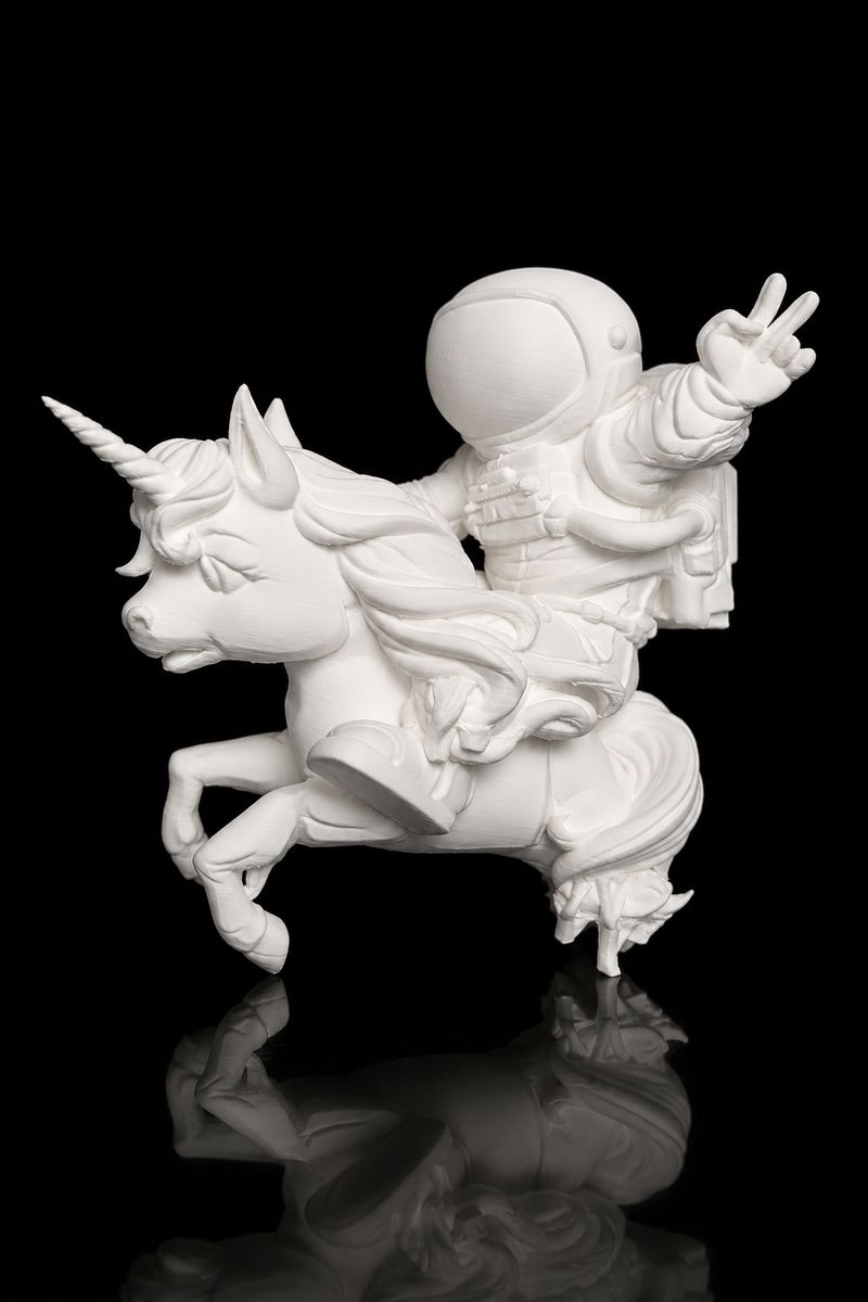 Unpainted white 3D printed unicorn and astronaut cake topper